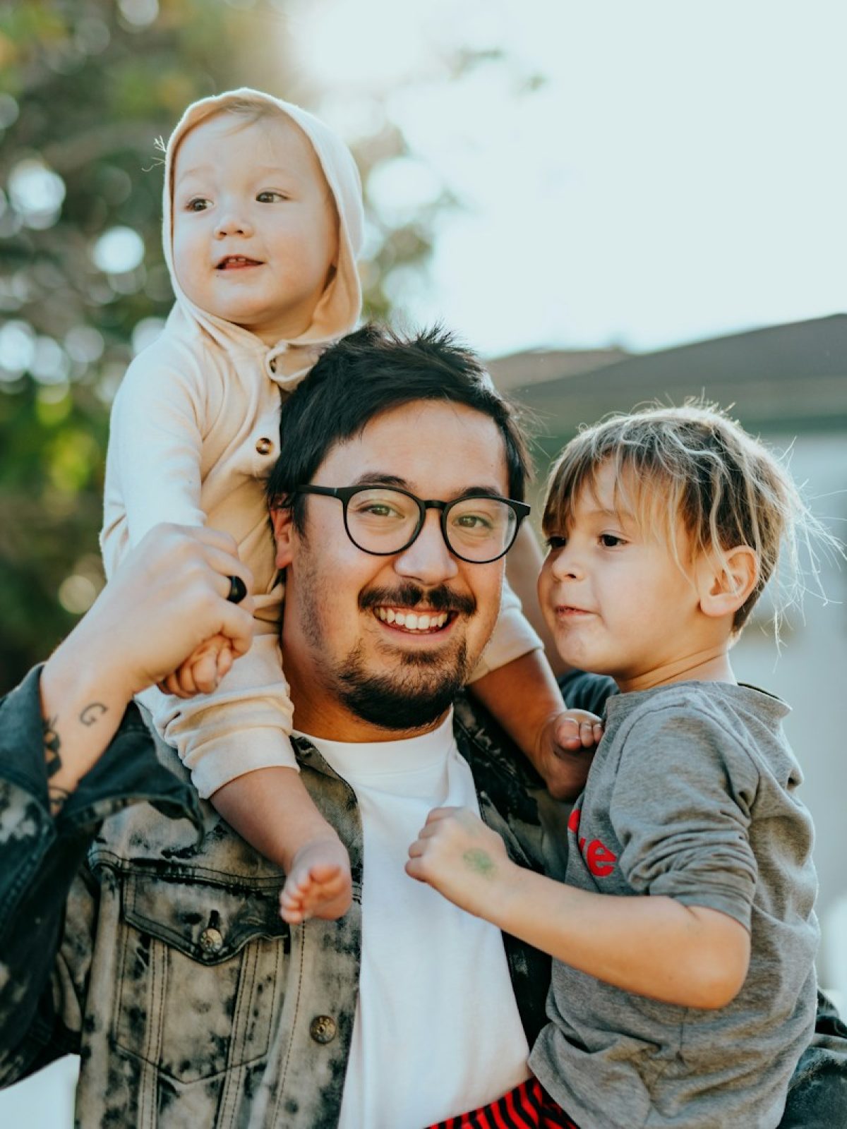 man in white shirt carrying girl in gray shirt